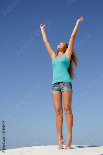 outdoor portrait of young happy woman isolated over blue sky