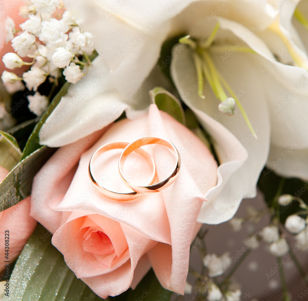 Fototapeta premium Gold wedding rings on flower