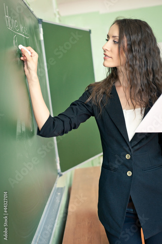 woman writing on blackboard at classroom