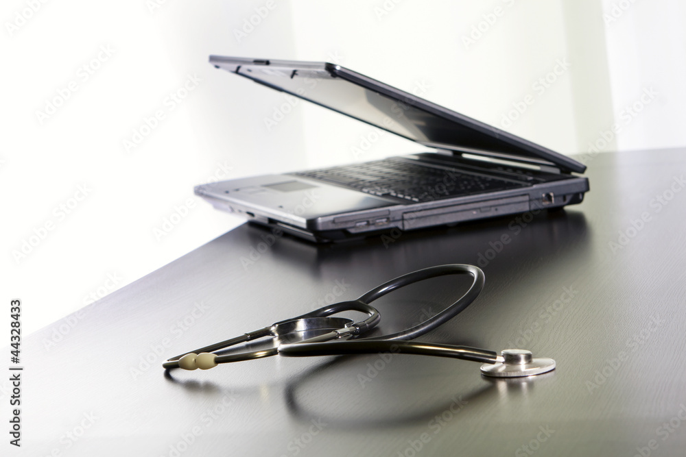 Medical stethoscope and a laptop on the table. Medical stethoscope and a laptop on the table.