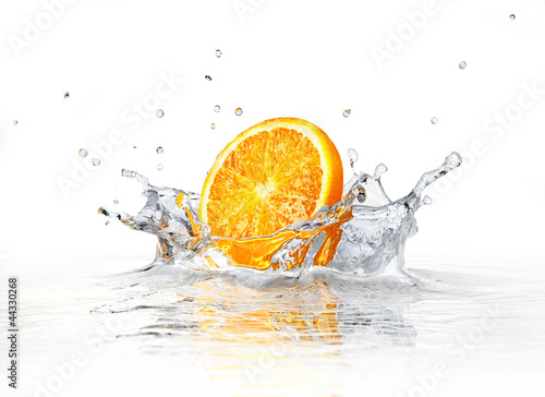 Orange slice falling and splashing into clear water. © matis75