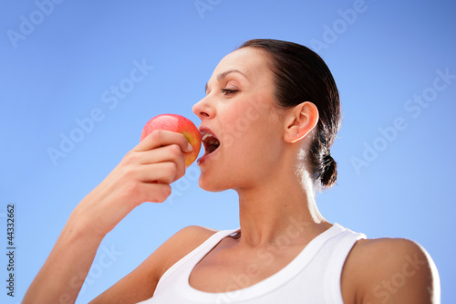 Brunette biting into tasty apple