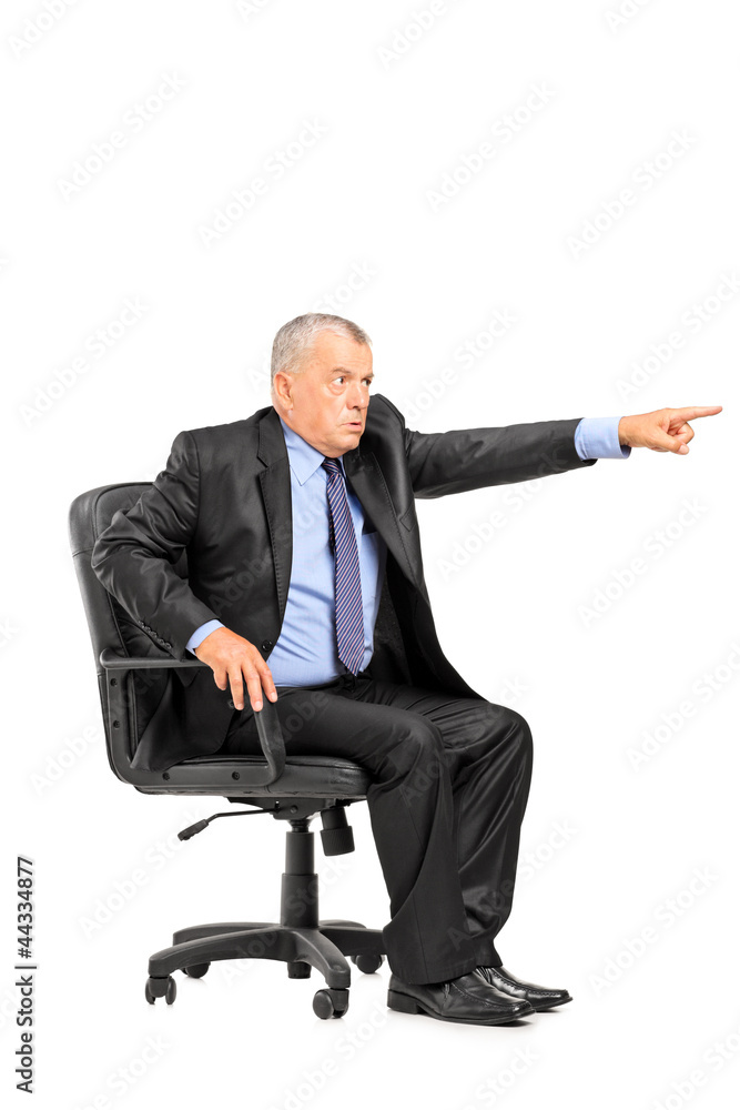 Angry boss sitting in armchair and pointing his finger