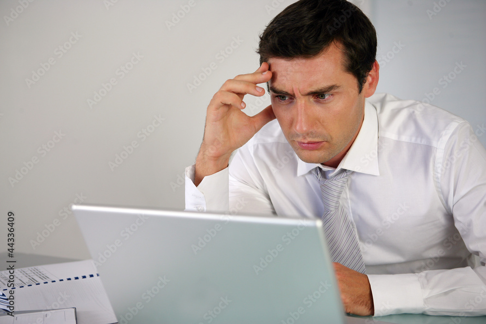Businessman getting stressed at laptop Businessman getting stressed at laptop