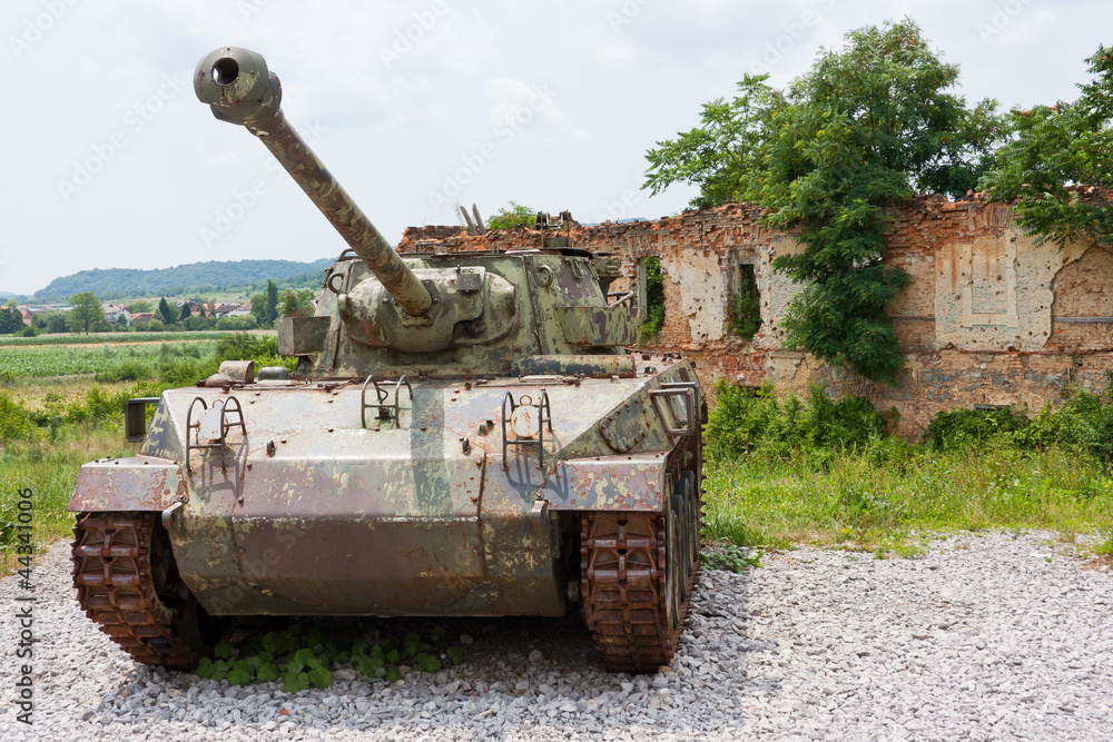 Tank M18 in front of broken house in Croatia Tank M18 in front of broken house in Croatia