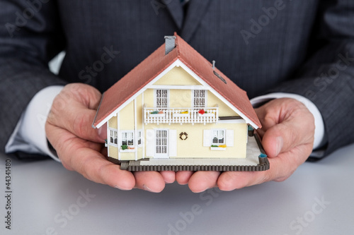 Businessman presenting house model