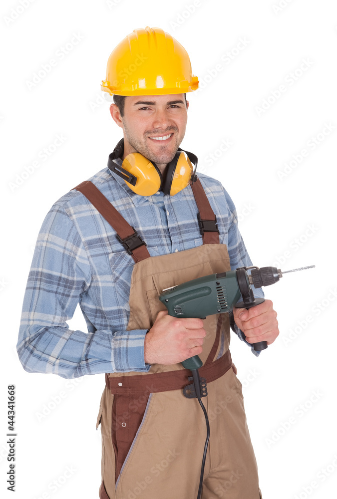 Worker holding drill and wearing hard hat