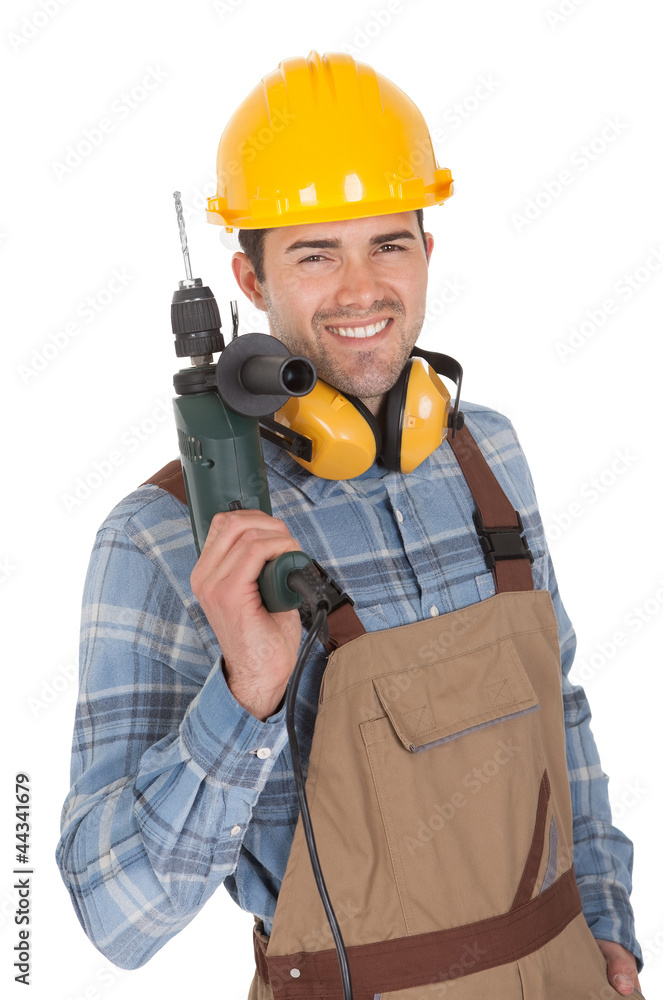 Worker holding drill and wearing hard hat Worker holding drill and wearing hard hat