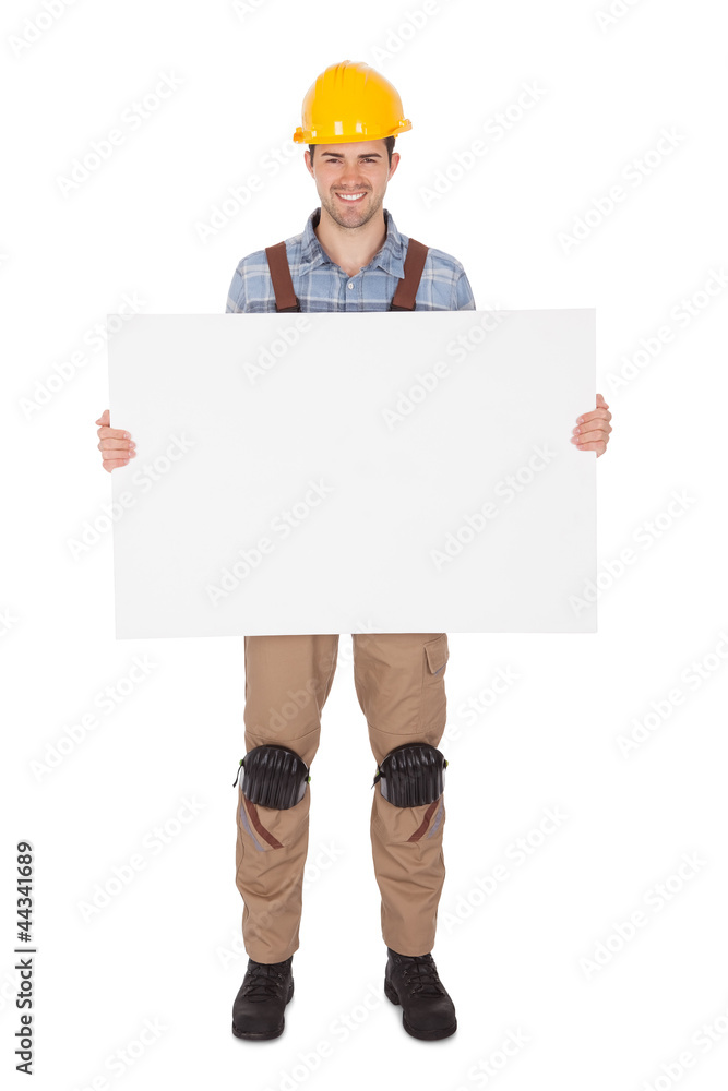 Worker wearing hard hat and holding empty banner Worker wearing hard hat and holding empty banner