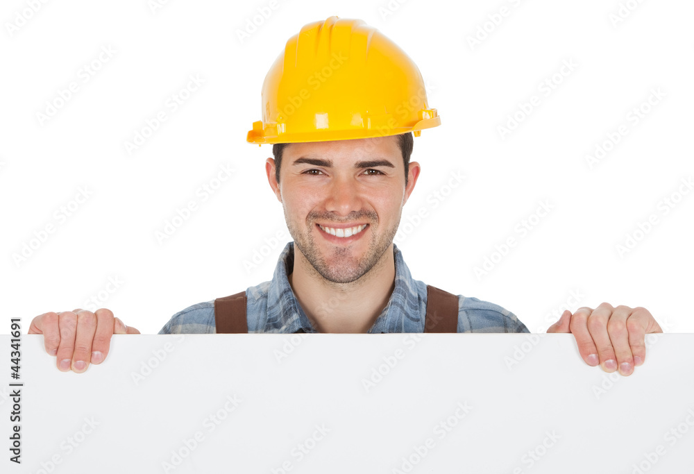 Worker wearing hard hat and holding empty banner Worker wearing hard hat and holding empty banner