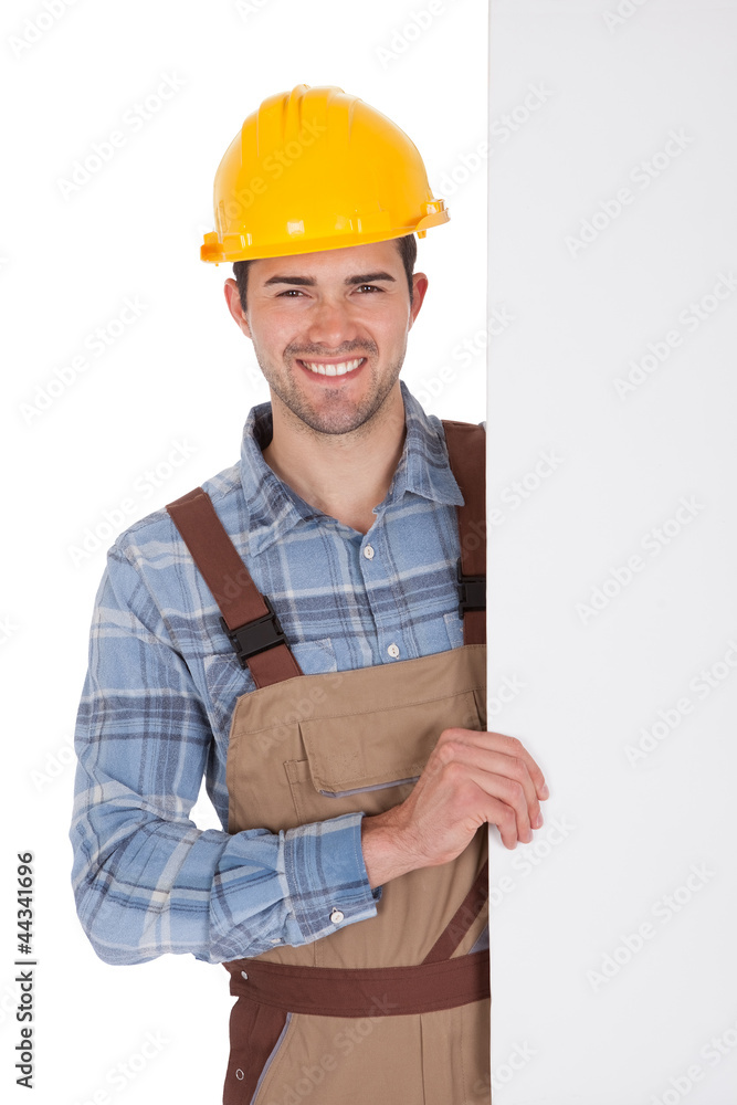 Worker wearing hard hat and holding empty banner Worker wearing hard hat and holding empty banner