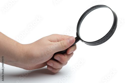Man's hand holding magnifying glass