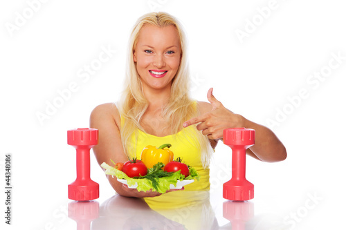 Portrait of vegetarian posing in kitchen with vegetables photo