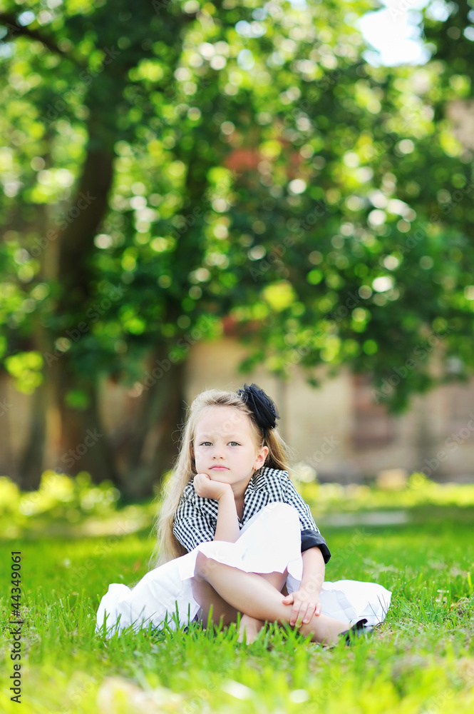 Portrait of serious child resting her chin on hand, while sittin Portrait of serious child resting her chin on hand, while sittin