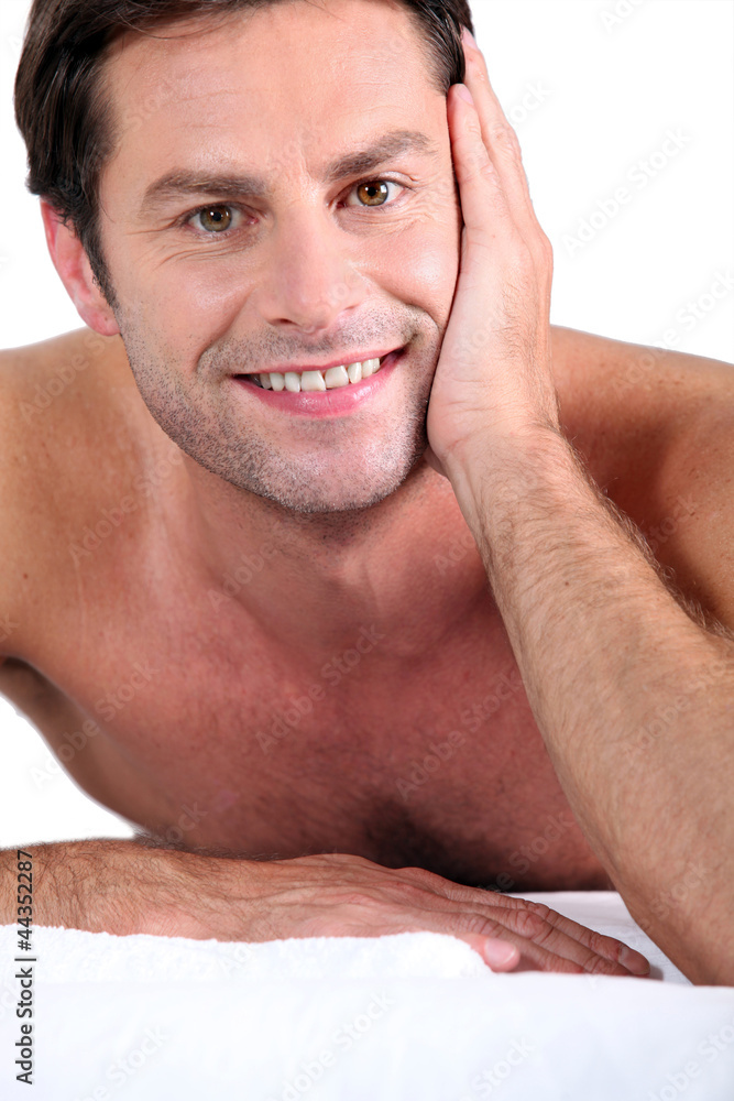 Obraz premium Naked man lying on massage table