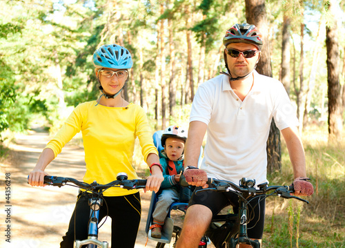 Family on the bike in the sunny forest