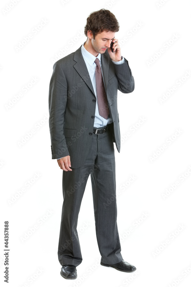 Full length portrait of businessman speaking mobile