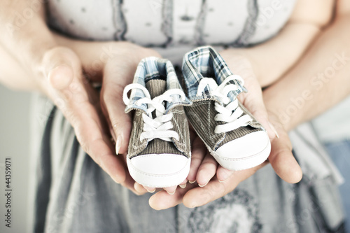 Newborn baby booties in parents hands photo
