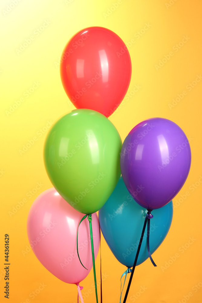 colorful balloons on yellow background close-up