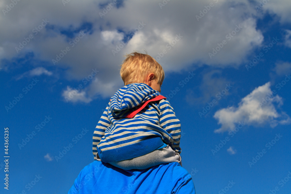 baby sitting on father