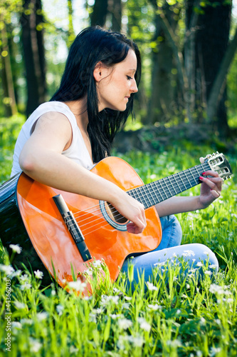 Young woman playing the guitar outdoors