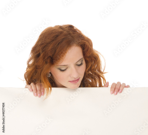 Young teenage girl hiding behind a billboard and looking down