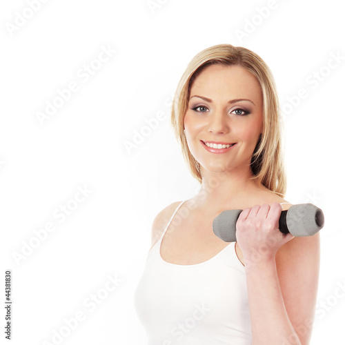 A young and happy blond woman holding a dumbbell