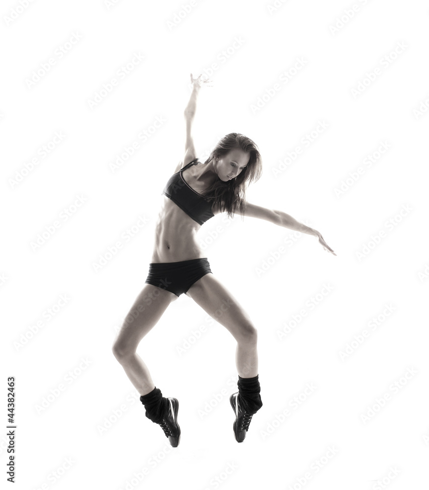 A young and fit female dancer caught in a hilarious jump