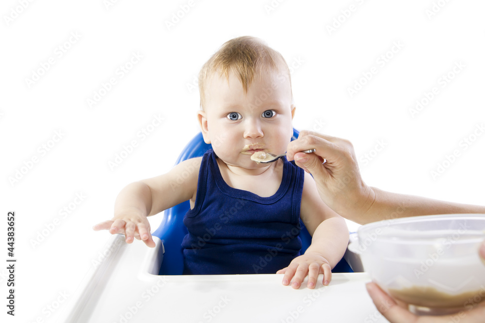 A young gray-eyed child feeding porridge A young gray-eyed child feeding porridge