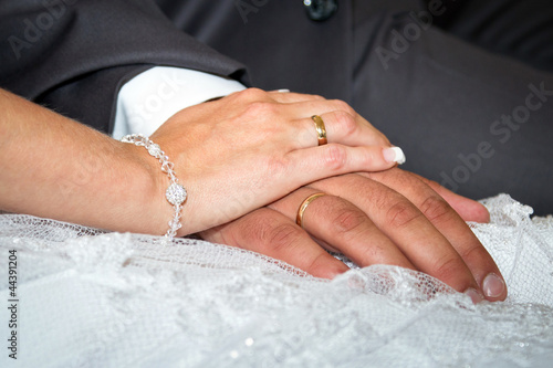Married couple holding hands together with wedding rings