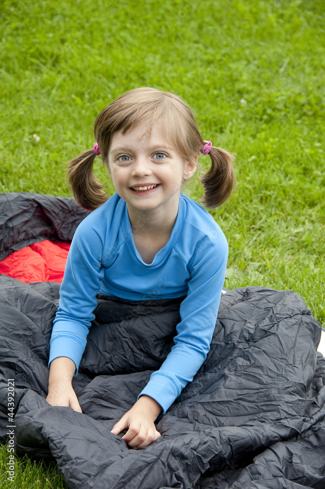 little girl on sleeping bag - camping concept little girl on sleeping bag - camping concept