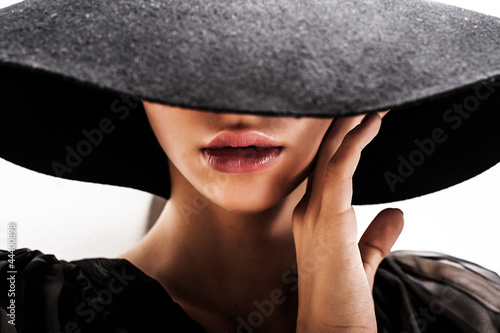 girl in black hat touching face and lips