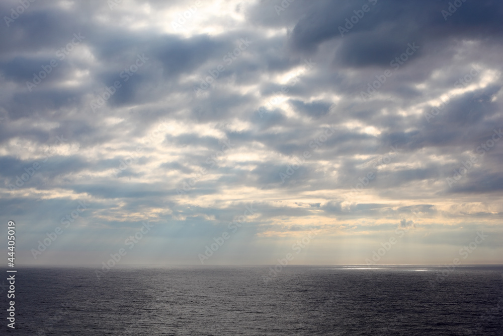 gray clouds over dark and cold sea;