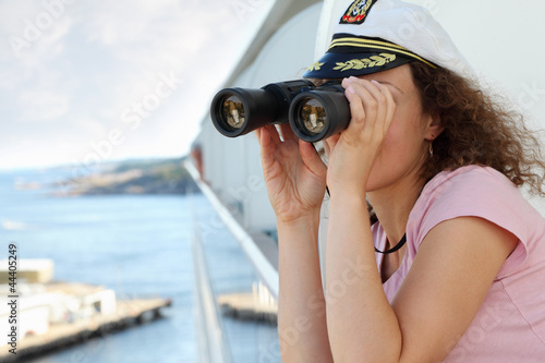 young woman dressed in cap stand on ship board