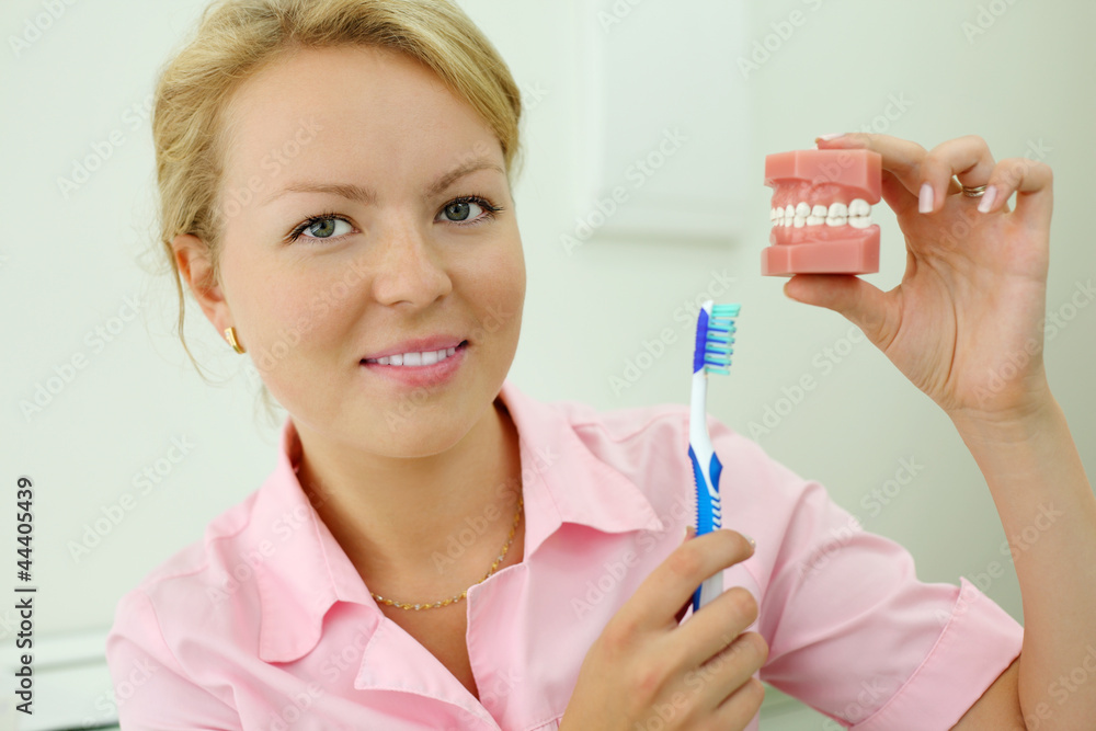 Dentist shows how to correctly brush teeth and looks at camera Dentist shows how to correctly brush teeth and looks at camera
