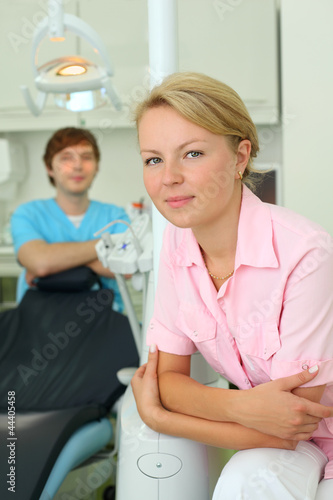 Dentist looks at camera in cabinet of dental clinic