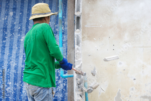 builder hitting a wall with a sledge hammer