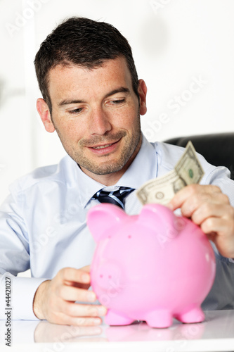 Fototapet young man and piggy bank