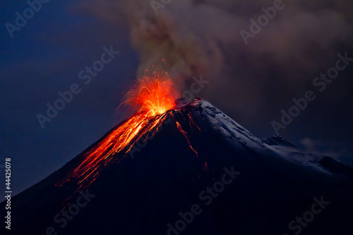 Tungurahua Volcano eruption with blue skies and lava photo