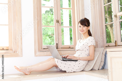 Beautiful young woman using a laptop computer. Portrait of asian