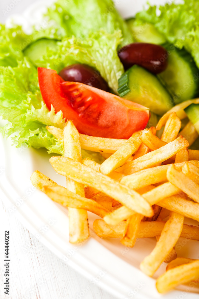 French fries with vegetables on a plate French fries with vegetables on a plate