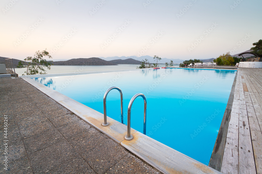 Blue swimming pool with Mirabello Bay view on Crete, Greece