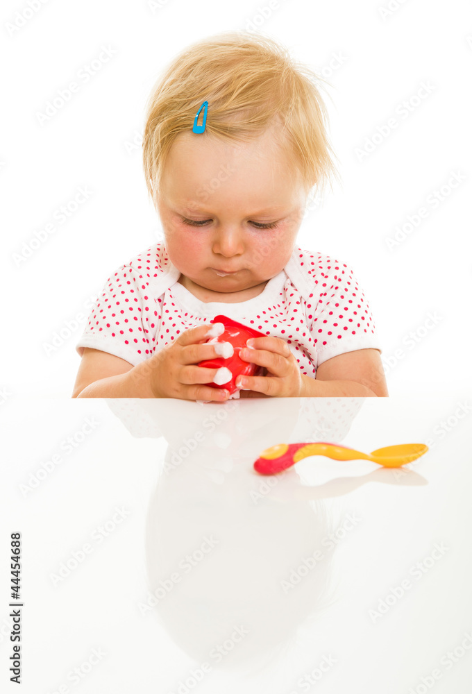 Cute infant girl learining to eat with spoon Cute infant girl learining to eat with spoon