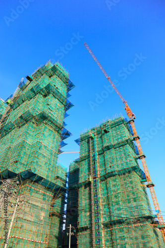 Construnction site - imcomplete building and cranes photo