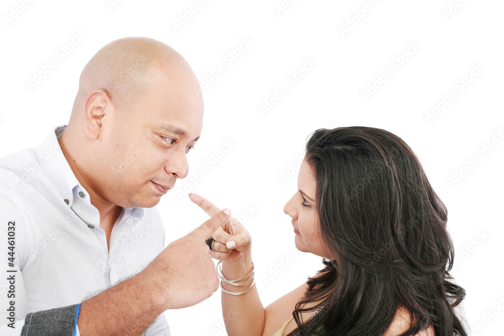 Young couple pointing at each other against a white background Young couple pointing at each other against a white background