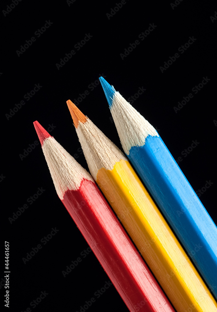 Naklejka premium Blue, Yellow and Red Pencils on Black Background