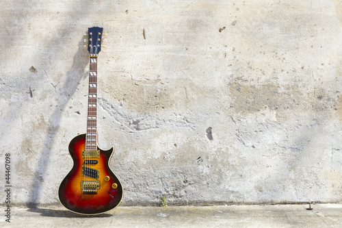 electric guitar in front of a vintage wall © alexandre zveiger