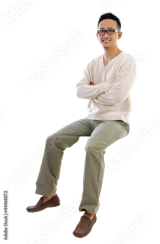 Full body Asian man sitting on a transparent block