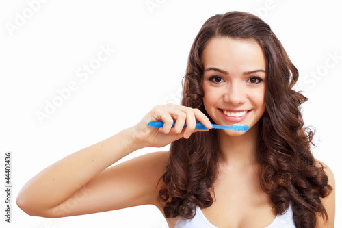 Young woman at home brushing teeth