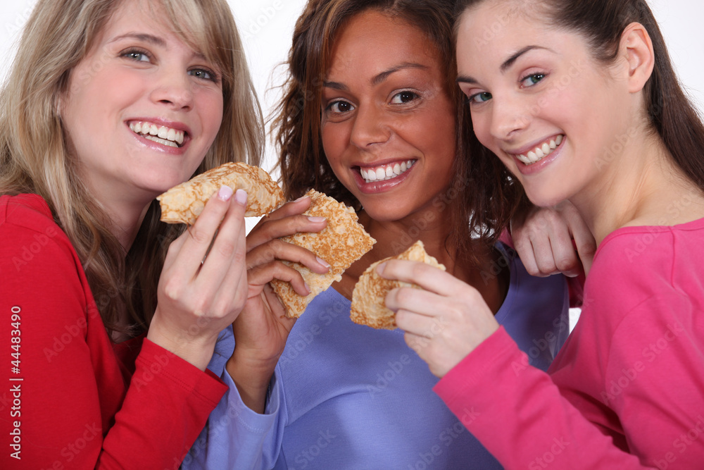 three friends eating pancakes